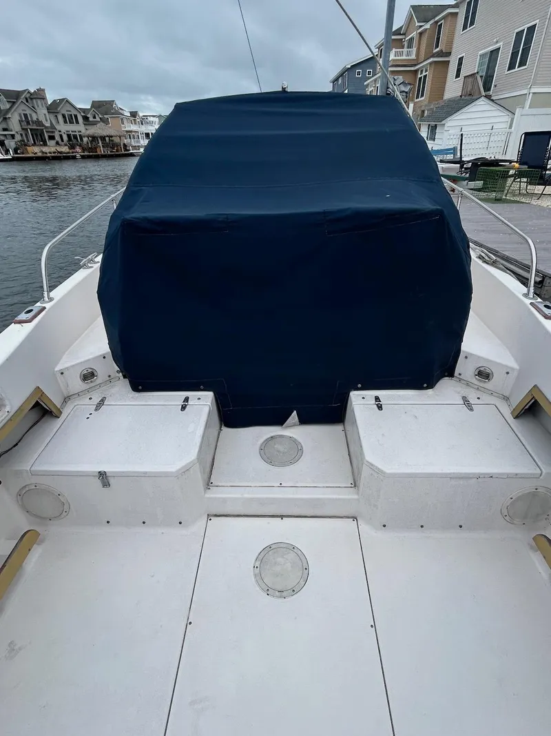 Slide: The Image of 1993 Grady-White 24 Explorer boat with covered seating, docked by waterfront homes. - 6