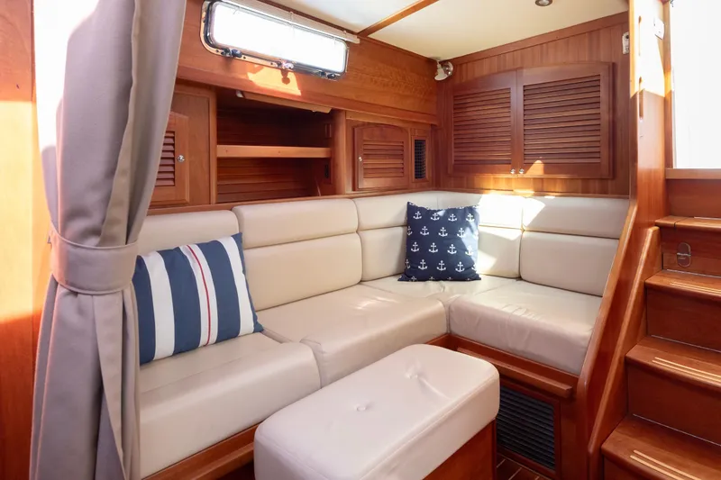 Slide: The Image of 2008 Sabre 34 Express yacht interior with cozy seating and nautical-themed pillows. - 13