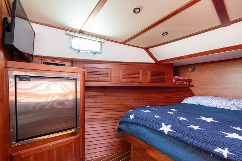 Slide: The Image of 2008 Sabre 34 Express cabin with wood paneling, bed, and TV. - 17
