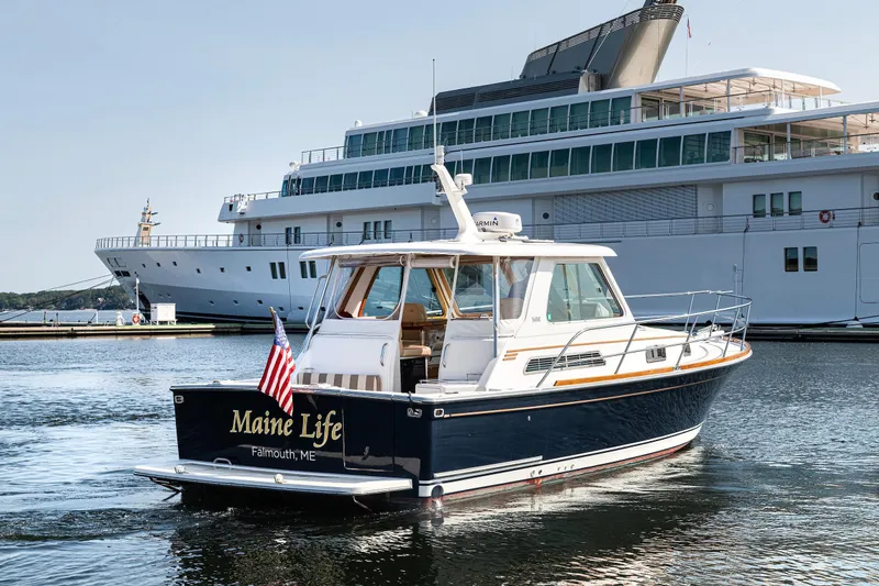 Slide: The Image of 2008 Sabre 34 Express boat named "Maine Life" in a marina setting. - 2