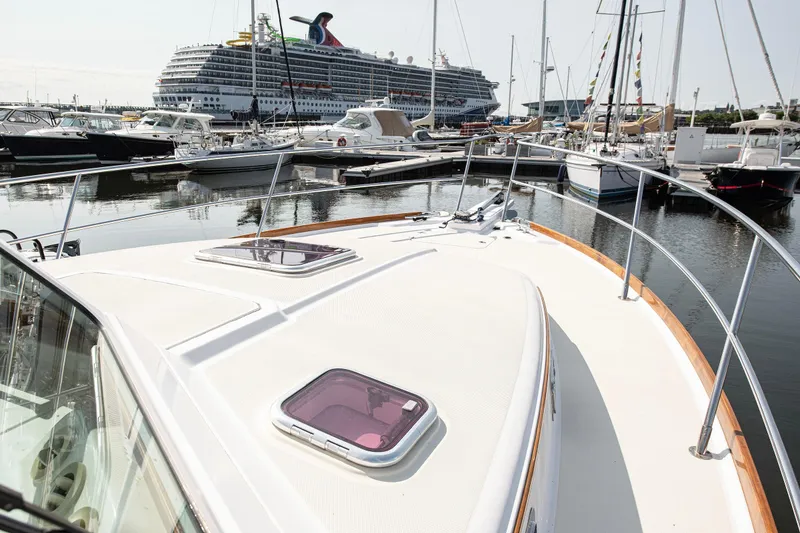 Slide: The Image of 2008 Sabre 34 Express yacht docked in marina with cruise ship in background. - 21