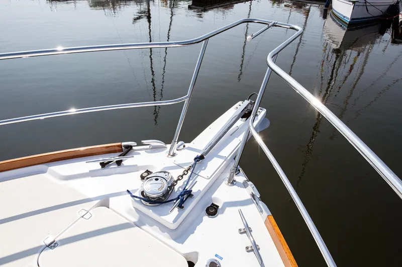 Slide: The Image of Sabre 34 Express 2008 boat bow with anchor and railing on calm water. - 22