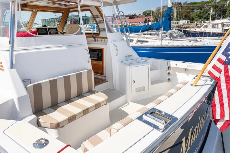 Slide: The Image of 2008 Sabre 34 Express yacht with striped seating and American flag in marina. - 3