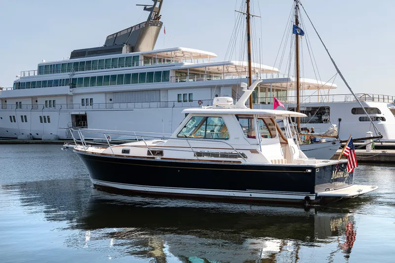 Slide: The Image of 2008 Sabre 34 Express yacht docked in marina, with large ship in background. - 4