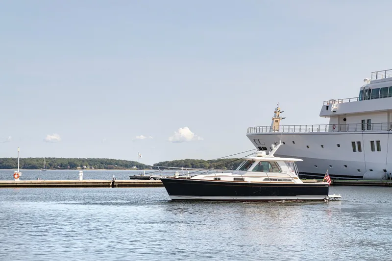 Slide: The Image of 2008 Sabre 34 Express yacht cruising near a large docked ship. - 5