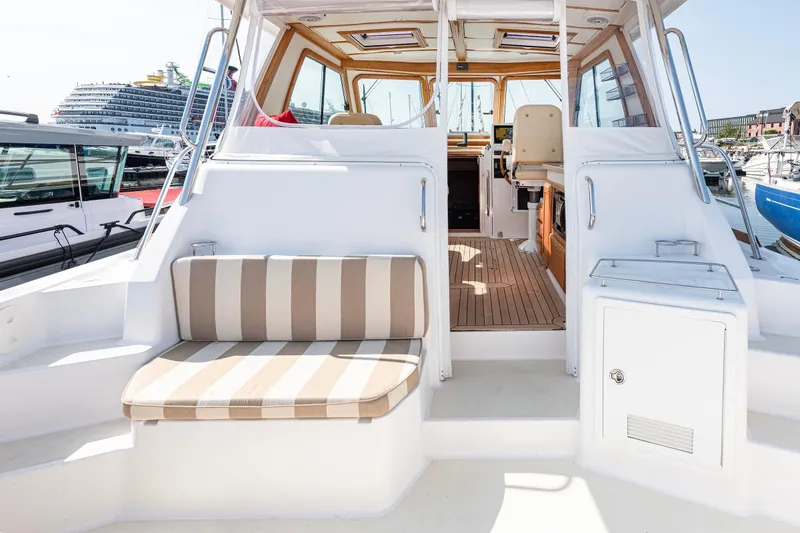 Slide: The Image of 2008 Sabre 34 Express boat interior with striped seating and wooden accents. - 6