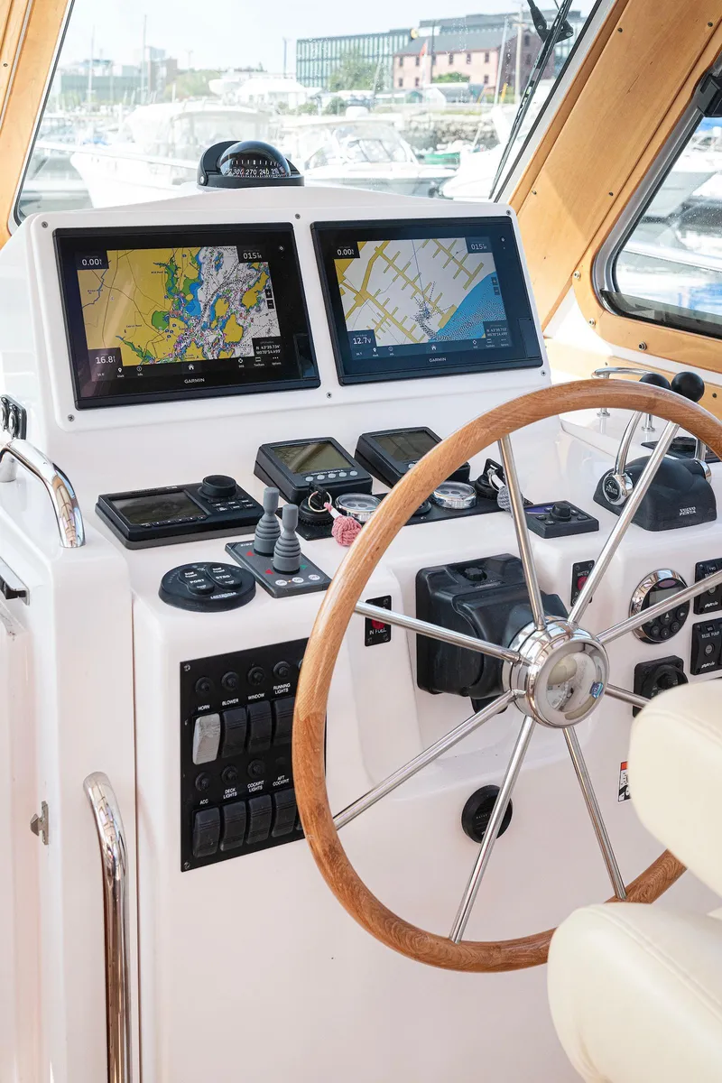 Slide: The Image of 2008 Sabre 34 Express boat helm with navigation screens and wooden steering wheel. - 7
