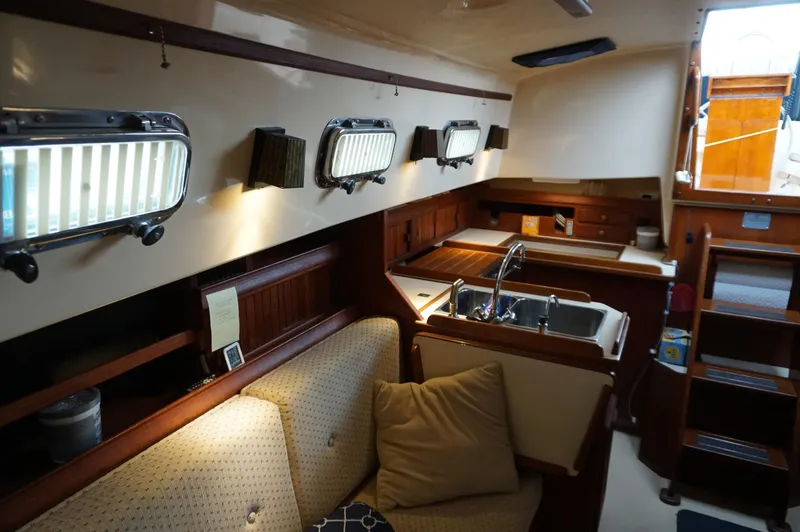 Slide: The Image of Interior of a 1994 Island Packet 32 sailboat, featuring a cozy cabin and kitchenette. - 14