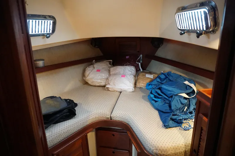 Slide: The Image of 1994 Island Packet 32 sailboat cabin with storage bags and portholes. - 19