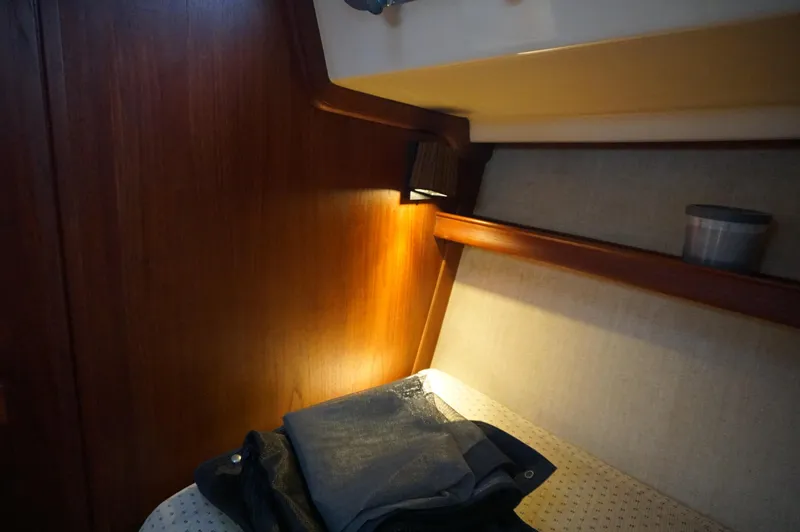 Slide: The Image of Cozy cabin interior of 1994 Island Packet 32 sailboat with warm lighting and wooden accents. - 22