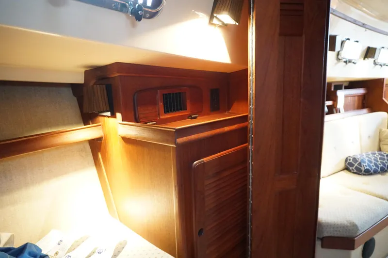 Slide: The Image of Interior of a 1994 Island Packet 32 sailboat, featuring wooden cabinetry and cozy seating. - 23