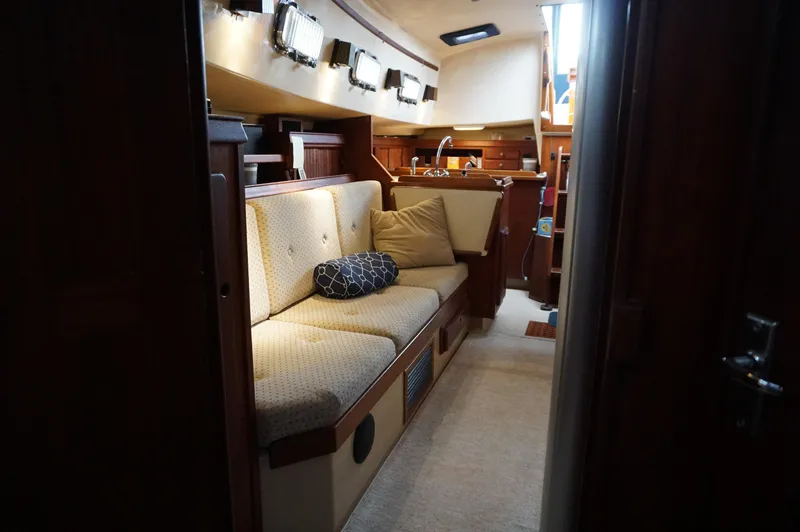 Slide: The Image of Interior of 1994 Island Packet 32 sailboat with cozy seating and wooden accents. - 24