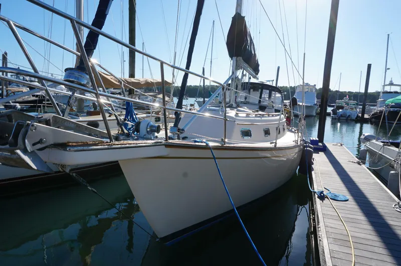 Slide: The Image of 1994 Island Packet 32 sailboat docked at marina under clear blue sky. - 3