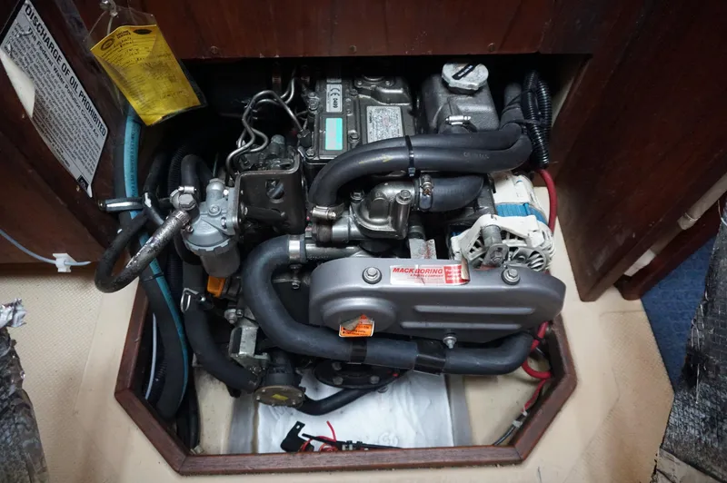 Slide: The Image of Engine compartment of a 1994 Island Packet 32 sailboat, showcasing mechanical components. - 30