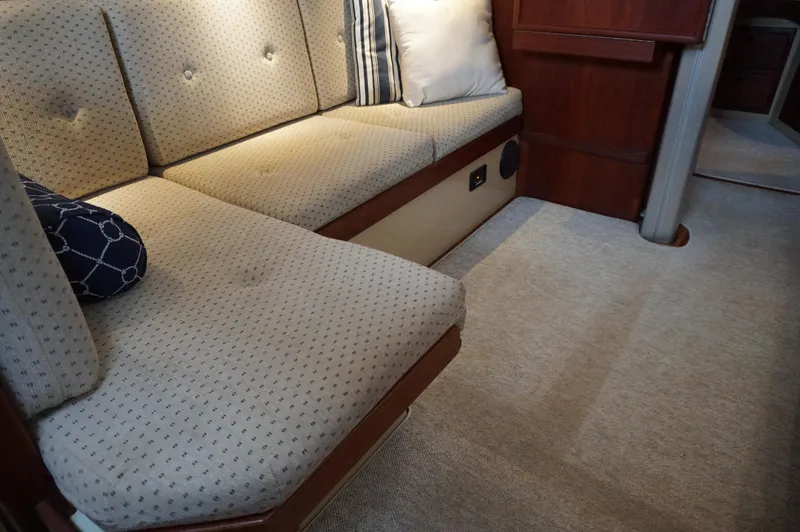 Slide: The Image of Interior of 1994 Island Packet 32 sailboat with cushioned seating and carpeted floor. - 33