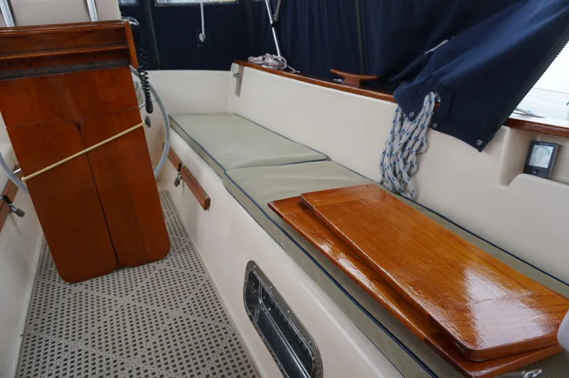 Slide: The Image of 1994 Island Packet 32 sailboat interior with wooden accents and cushioned seating. - 34