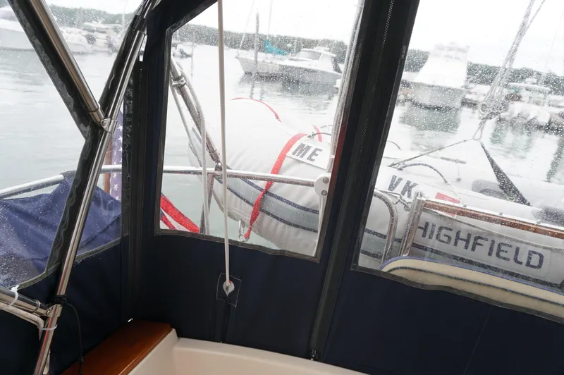 Slide: The Image of 1994 Island Packet 32 sailboat cockpit view with dinghy and marina background. - 37