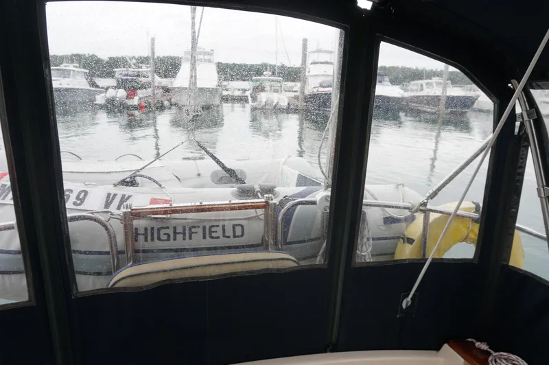 Slide: The Image of 1994 Island Packet 32 sailboat view from cockpit, marina background, rainy day. - 38