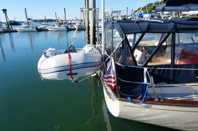 Slide: The Image of 1994 Island Packet 32 sailboat docked with dinghy and American flag. - 4