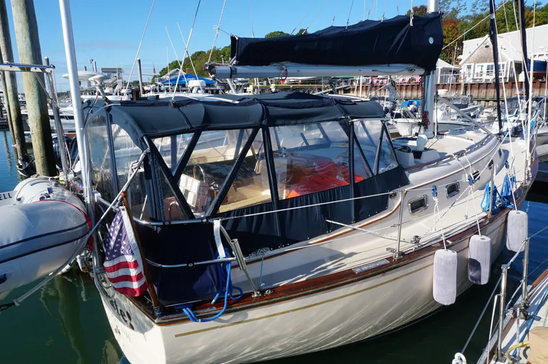 Slide: The Image of 1994 Island Packet 32 sailboat docked with canopy and American flag. - 5