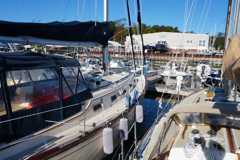 Slide: The Image of 1994 Island Packet 32 sailboat docked in a marina, surrounded by other boats. - 6