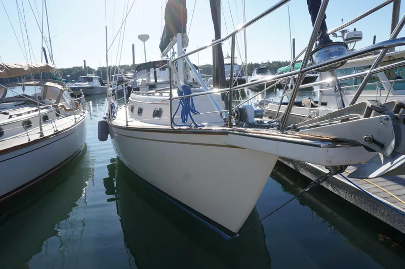 Slide: The Image of 1994 Island Packet 32 sailboat docked in a marina, surrounded by other boats. - 8