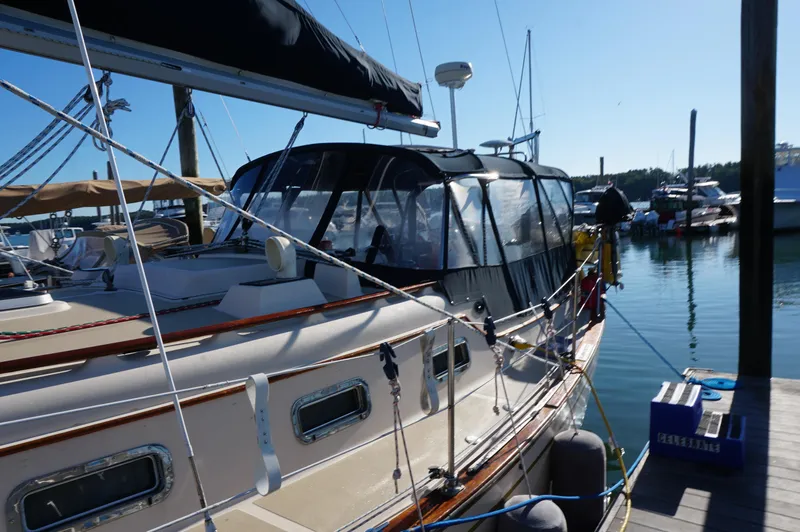Slide: The Image of 1994 Island Packet 32 sailboat docked at marina, featuring a covered cockpit. - 9