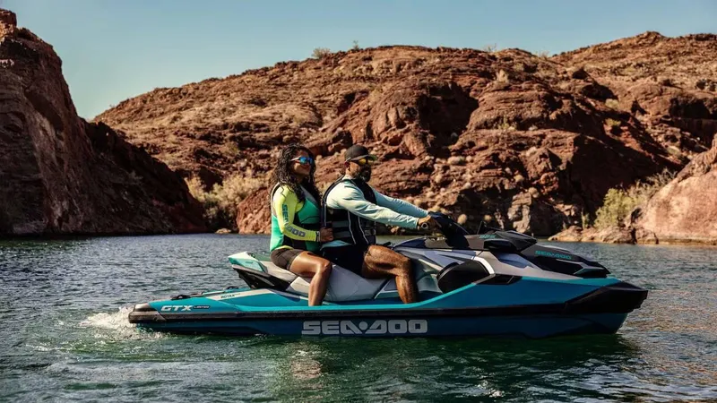 Slide: The Image of 2025 Sea-Doo GTX Limited 325 jet ski on scenic water with two riders. - 6