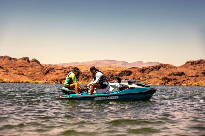 Slide: The Image of 2025 Sea-Doo GTX Limited 325 on scenic lake with rocky hills in background. - 9