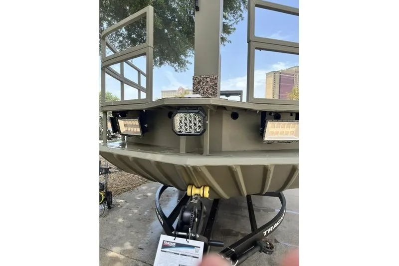 Slide: The Image of 2025 Tracker Grizzly 2072 CC Sportsman Kicker boat front view with mounted lights. - 6