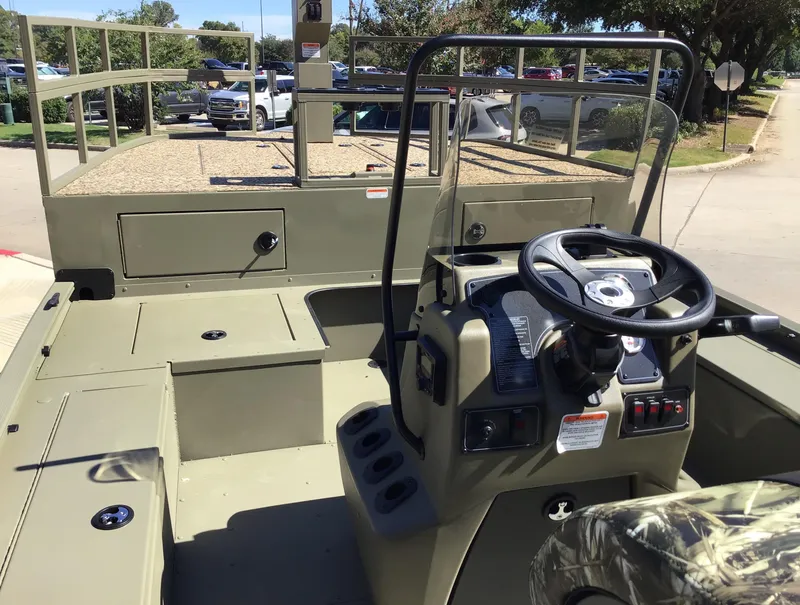 Slide: The Image of 2025 Tracker Grizzly 2072 CC Sportsman Kicker boat interior with steering console. - 2