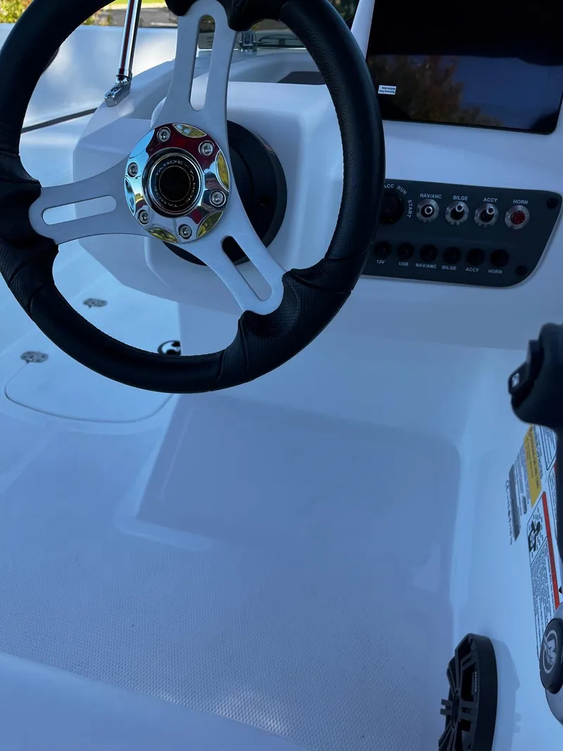 Slide: The Image of 2024 Tahoe T16 boat dashboard with steering wheel and control panel. - 3