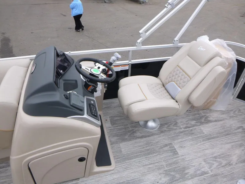 Slide: The Image of 2024 Ranger Reata 223C boat interior with steering console and plush seating. - 12