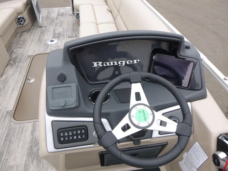 Slide: The Image of 2024 Ranger Reata 223C boat dashboard with steering wheel and controls. - 13
