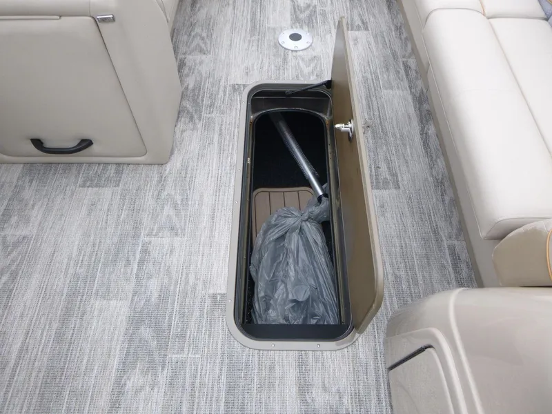 Slide: The Image of 2024 Ranger Reata 223C boat interior storage compartment with gray flooring. - 17