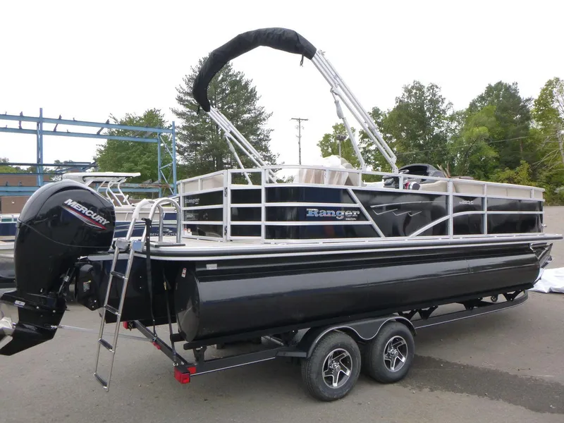 Slide: The Image of 2024 Ranger Reata 223C pontoon boat with Mercury outboard motor, parked on trailer. - 2