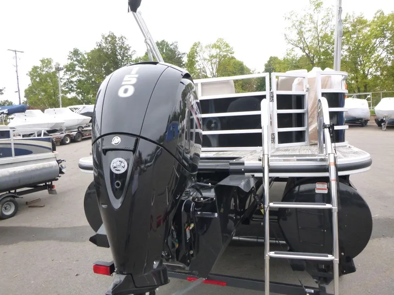 Slide: The Image of 2024 Ranger Reata 223C boat with powerful outboard motor and ladder, parked outdoors. - 3