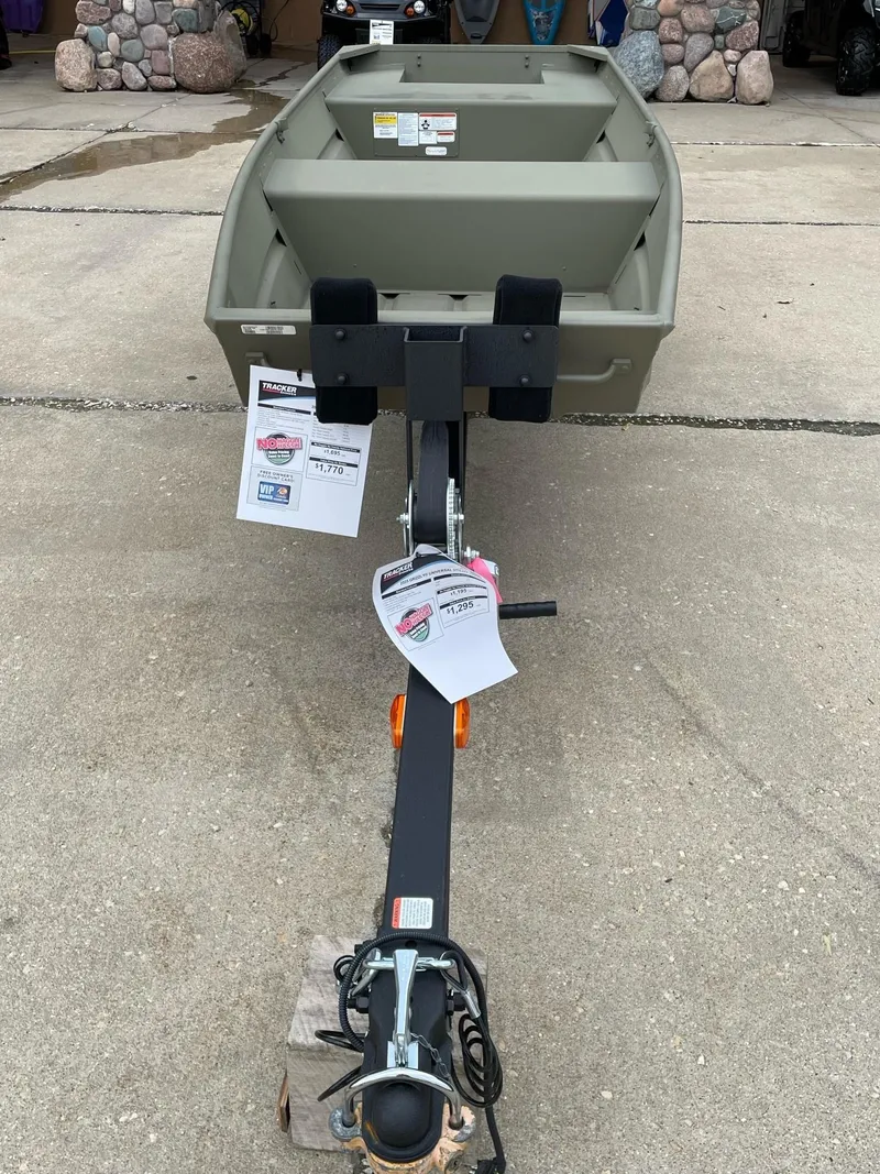 Slide: The Image of 2025 Tracker Grizzly 1436 Utility boat on trailer, displayed outdoors. - 2