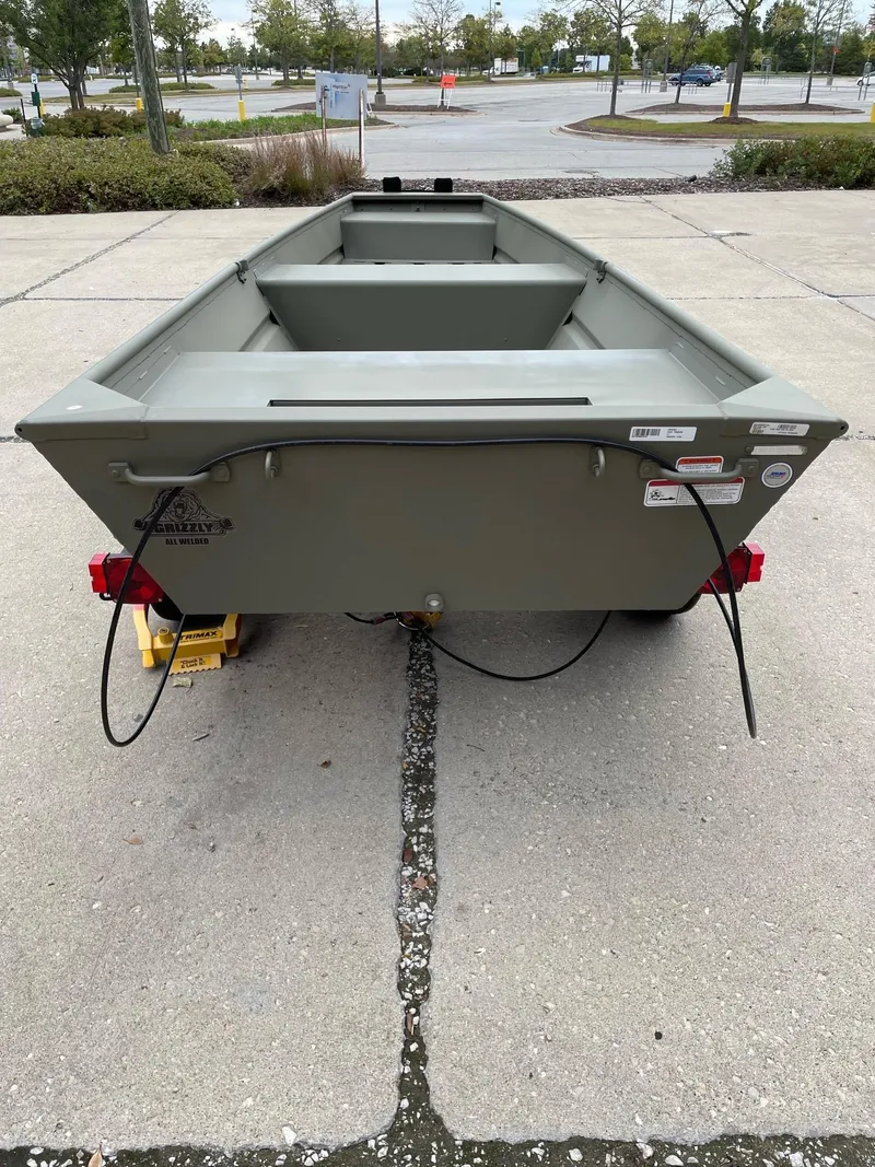 Slide: The Image of 2025 Tracker Grizzly 1436 Utility boat on trailer, parked outdoors. - 4