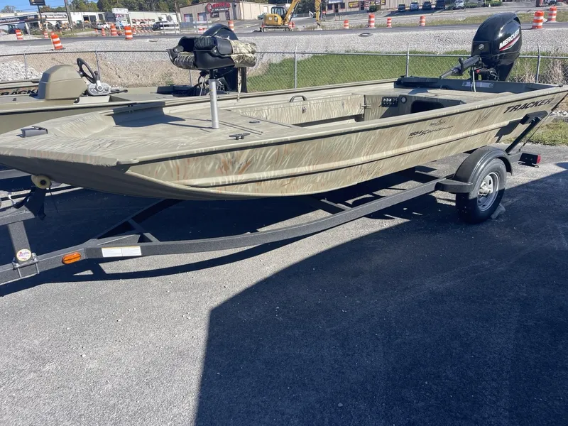Slide: The Image of 2025 Tracker Grizzly 1654 T Sportsman boat on trailer in outdoor setting. - 2