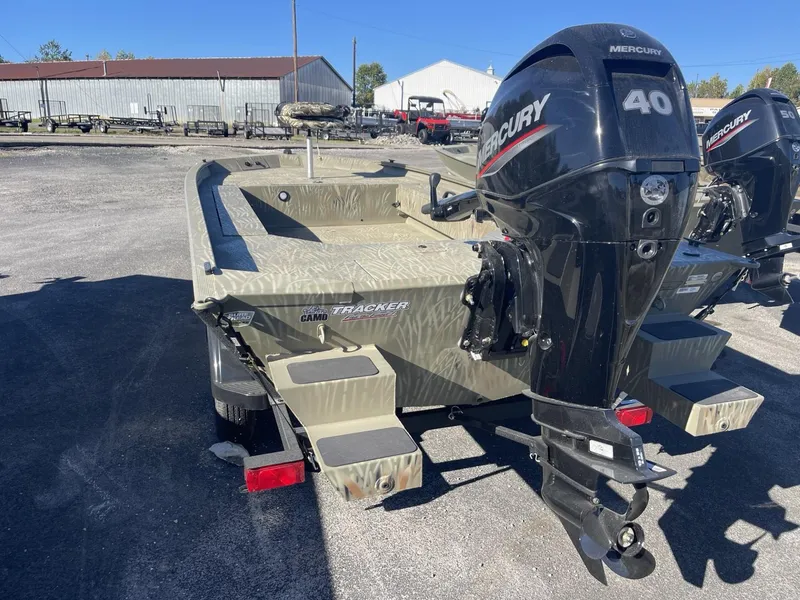 Slide: The Image of 2025 Tracker Grizzly 1654 T Sportsman boat with Mercury 40 engine, parked outdoors. - 3