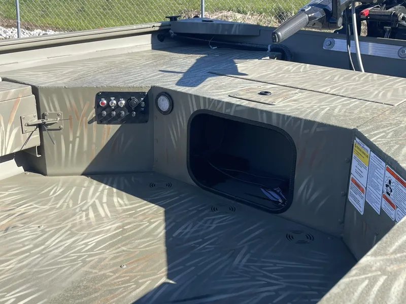 Slide: The Image of 2025 Tracker Grizzly 1654 T Sportsman boat interior with control panel and storage compartment. - 5