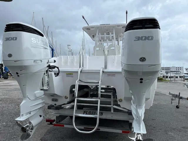 Slide: The Image of 2025 Twin Vee 280 GFX2 CC boat with dual Suzuki 300 engines, docked on trailer. - 20