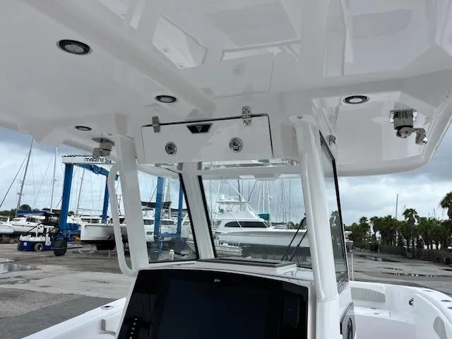 Slide: The Image of 2025 Twin Vee 280 GFX2 CC boat interior with modern console and overhead storage. - 24