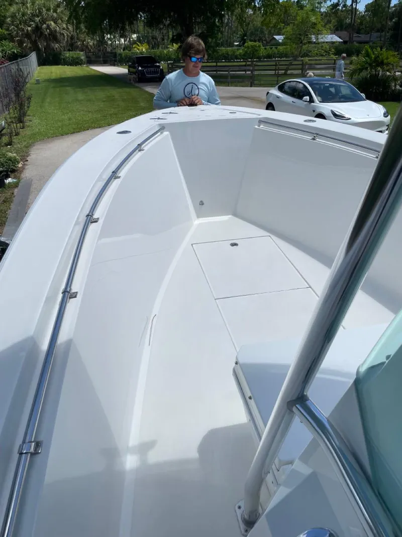 Slide: The Image of 1995 Contender 21 Open boat with spacious deck, parked outdoors. - 3