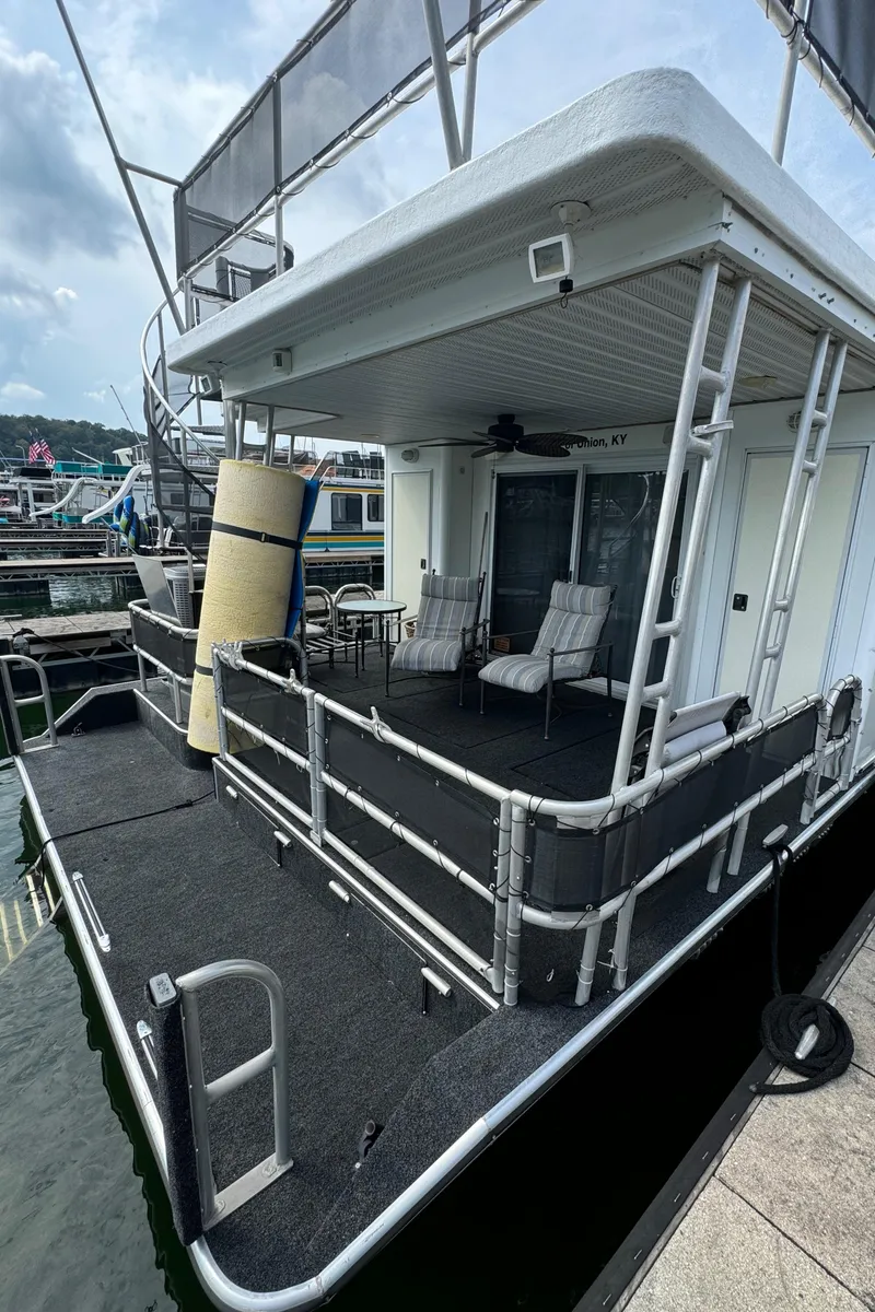 Slide: The Image of 1999 Sumerset 16 X 80 houseboat with spacious deck and seating at marina. - 10