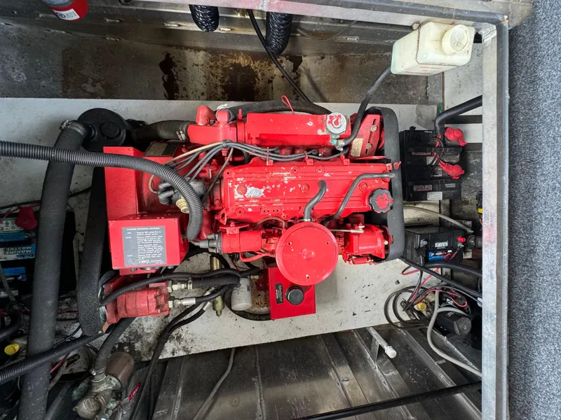 Slide: The Image of Engine compartment of a 1999 Sumerset 16 X 80 houseboat, featuring a red engine. - 11
