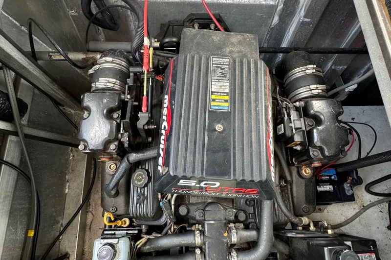 Slide: The Image of Engine compartment of a 1999 Sumerset 16 X 80 houseboat, featuring a MerCruiser 5.0L engine. - 12