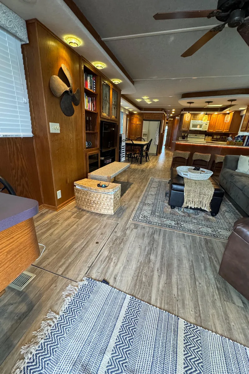 Slide: The Image of Interior of a 1999 Sumerset 16 X 80 houseboat with modern decor and wooden flooring. - 18