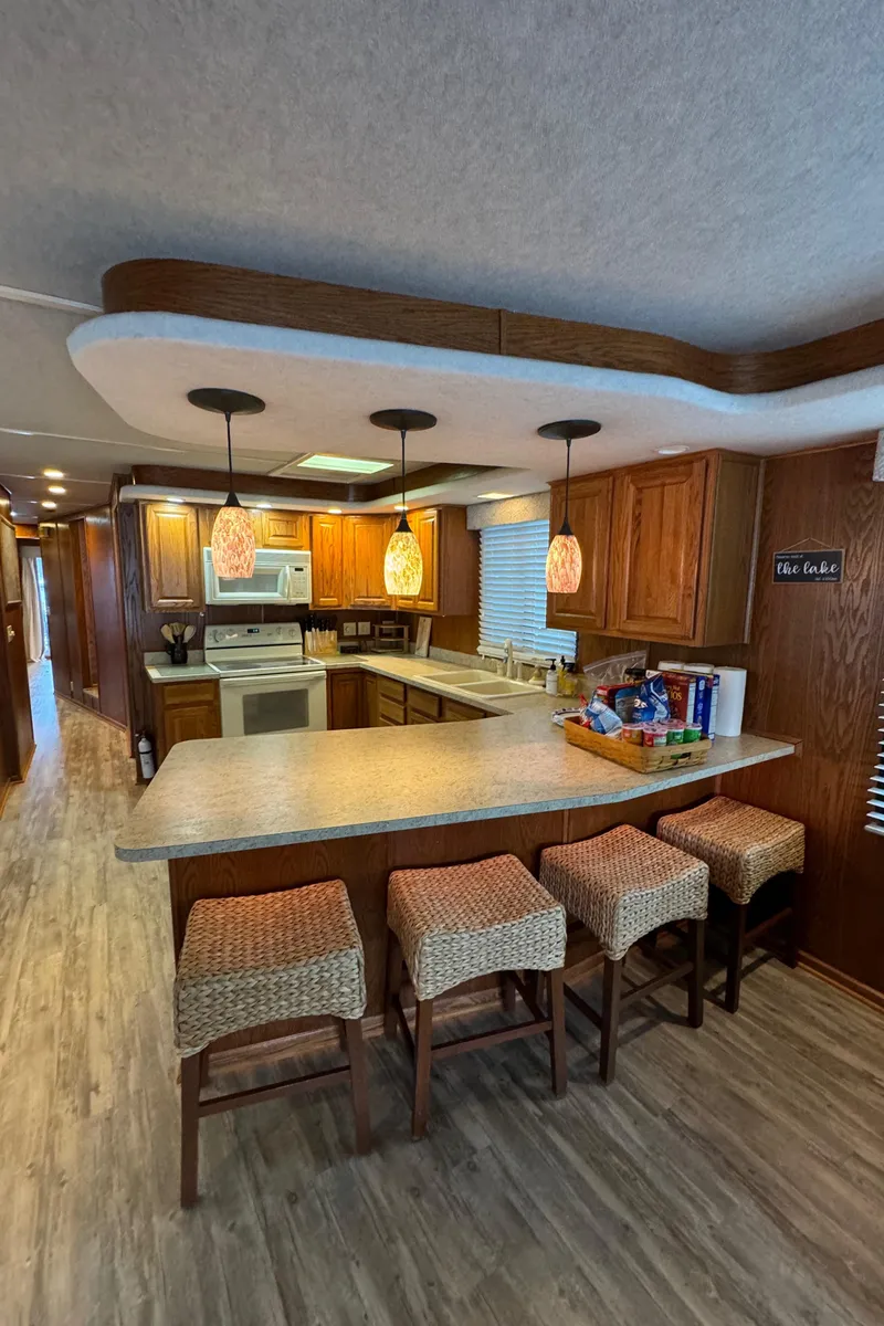 Slide: The Image of 1999 Sumerset 16 X 80 houseboat kitchen with modern lighting and bar seating. - 23